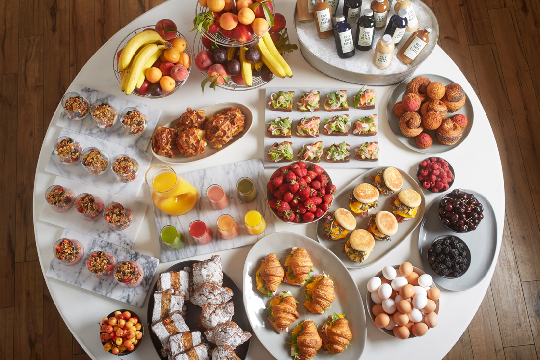 Breakfast Buffet with an assortment of Croissant Sandwiches, Yogurt Parfaits, Pastries, Hot Breakfast Sandwiches, Avocado Toast, Iced Coffees, Fresh Fruit and Juices  